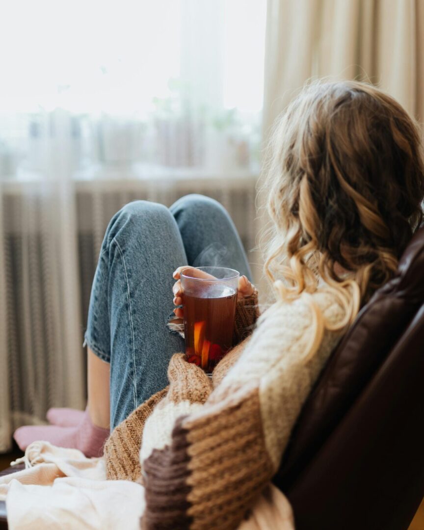 Woman sitting by window drinking tea